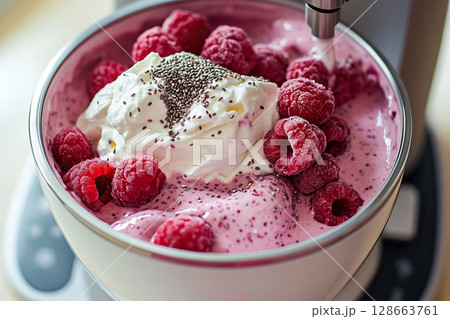 Homemade dessert. Stand mixer blends yogurt, raspberries and chia seeds into smoothie Homemade dessert. Stand mixer blends yogurt, raspberries and chia seeds into smoothie 128663761