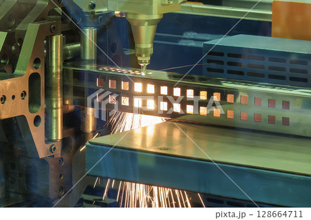 Close up scene the fiber laser cutting machine cut the square shape stainless steel tube with sparkling light. Close up scene the fiber laser cutting machine cut the square shape stainless steel tube with sparkling light. 128664711