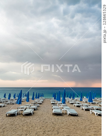 deck chairs and umbrellas on the sea beach in summer deck chairs and umbrellas on the sea beach in summer 128665329