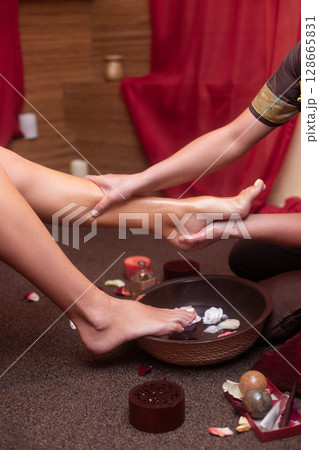 a masseuse in a cosmetology salon makes a Thai massage on the legs of a young girl a masseuse in a cosmetology salon makes a Thai massage on the legs of a young girl 128665831