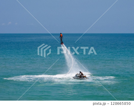 a guy flies on a flyboard at sea a guy flies on a flyboard at sea 128665850
