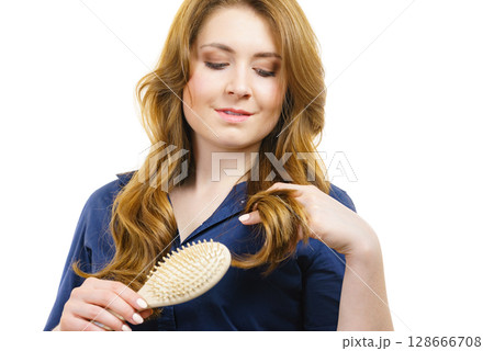 Woman brushing long healthy brown hair Woman brushing long healthy brown hair 128666708