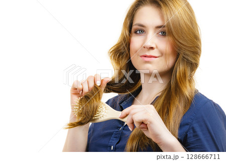 Woman brushing long healthy brown hair Woman brushing long healthy brown hair 128666711