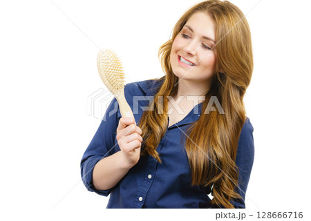 Woman brushing long healthy brown hair 128666716