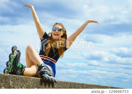 Fit girl with roller skates outdoor 128666753