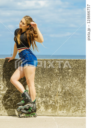 Happy young woman wearing roller skates 128666757