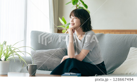 リビングのソファに座る笑顔の女性 128667494