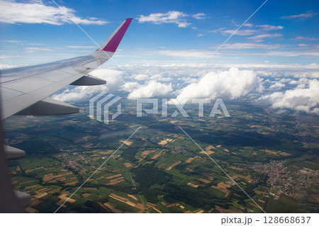 beautiful thick clouds in the sky from the height of the flight of the plane with a view of the wing with engines 128668637