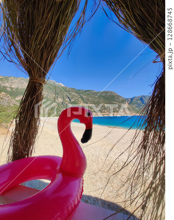 toy flamingo on the beach near the sea toy flamingo on the beach near the sea 128668745