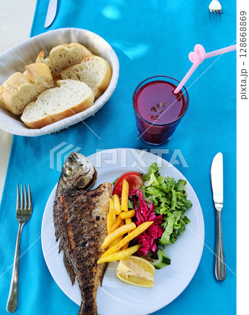 delicious and fresh dish with baked fish top view delicious and fresh dish with baked fish top view 128668869