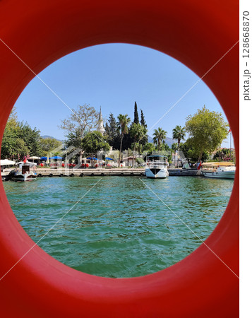 red lifebuoy on a boat swimmers in a pond red lifebuoy on a boat swimmers in a pond 128668870