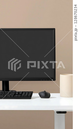 A computer monitor sits on a desk with a mouse and a keyboard A computer monitor sits on a desk with a mouse and a keyboard 128670234
