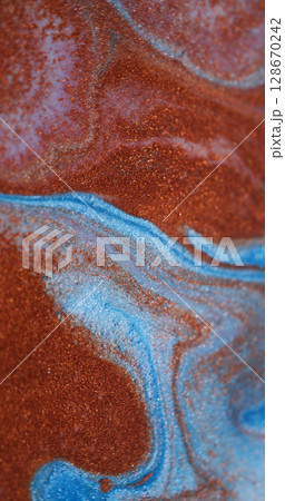 Splash art. Ink spilling. Defocused orange pink blue colorful sparkling flowing particles floating on abstract creative background. 128670242