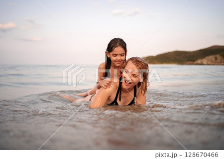 Laughter and splashes create unforgettable moments at the beach 128670466