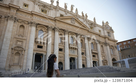 Woman in white dress gazing at Basilica facade Vatican, Italy July 20 2025  Woman in white dress gazing at Basilica facade Vatican, Italy July 20 2025  128671804