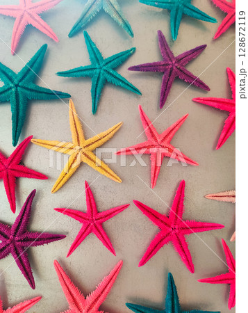 a composition of colored starfish on a gray background 128672119