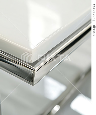 A table with a shiny silver edge and a white top 128672353