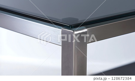 A table with a glass top and metal legs A table with a glass top and metal legs 128672384