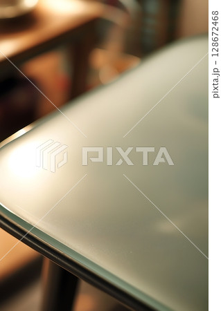 A table with a glass top and a cup on it 128672468