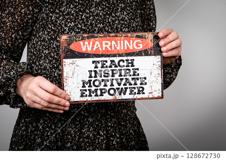 Woman Holding Inspirational Sign with Motivational Message to Teach, Inspire, Motivate, Empower 128672730