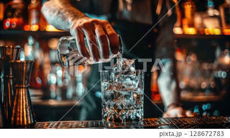 Skilled bartender in uniform carefully pours crafted cocktail into glass, close-up of liquid stream with bar counter background Skilled bartender in uniform carefully pours crafted cocktail into glass, close-up of liquid stream with bar counter background 128672783