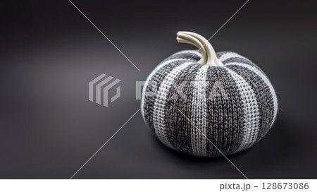 Knitted black and white pumpkin on dark background, highlighting sustainable Halloween decor. Perfect for DIY enthusiasts, showcasing handmade gifts and eco-friendly holiday decorations. Copy space Knitted black and white pumpkin on dark background, highlighting sustainable Halloween decor. Perfect for DIY enthusiasts, showcasing handmade gifts and eco-friendly holiday decorations. Copy space 128673086
