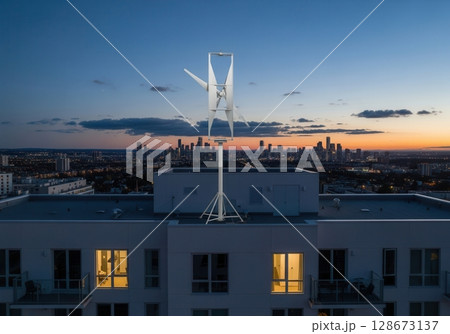 Vertical axis turbine on apartment rooftop during twilight with city skyline backdrop Vertical axis turbine on apartment rooftop during twilight with city skyline backdrop 128673137