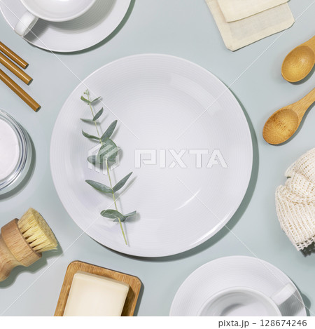 Zero waste kitchen cleaning concept. Eco friendly natural cleaning dishes with empty plate, bamboo dish brushes, soda and sprig of eucalyptus. No plastic, eco-friendly lifestyle. Top view, copy space 128674246