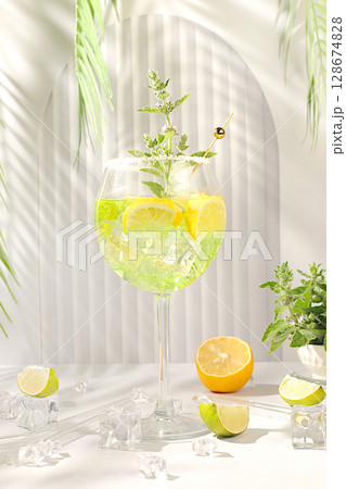 Sangria with lemon, mint, ice with tequila, vodka or soda water on elegant background, minimalist concept for bar, soft drink for weight loss and detox diet, advertising banner for cafe 128674828