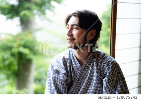 浴衣姿で旅館の窓際に座るインバウンドの観光客 128675242