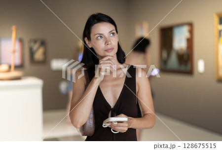 Young woman at a sculpture exhibition 128675515