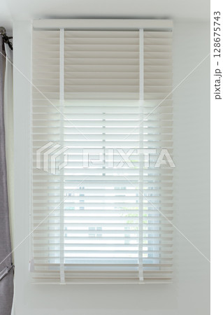 Sun-blocking blinds are hung on the windows. 128675743