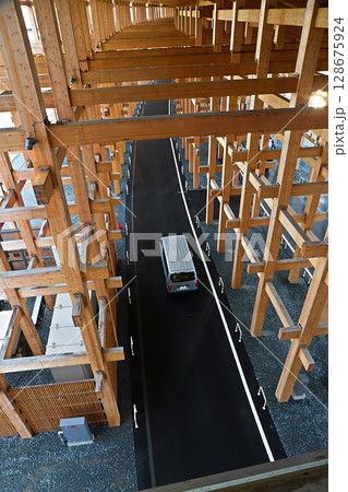 大阪　関西万博　夕刻の大屋根リングの下を走る西ゲート行きのバス 128675924