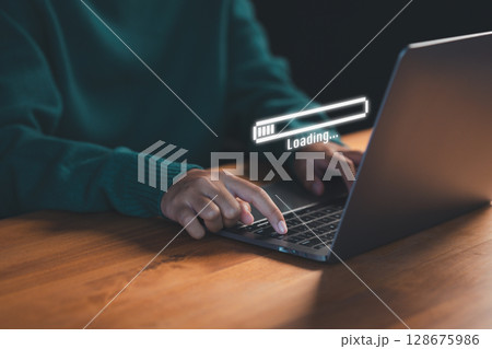 User types on a laptop with a floating "Loading..." progress bar, representing data processing or digital wait time in a modern tech environment, anticipation of technology responding. User types on a laptop with a floating "Loading..." progress bar, representing data processing or digital wait time in a modern tech environment, anticipation of technology responding. 128675986