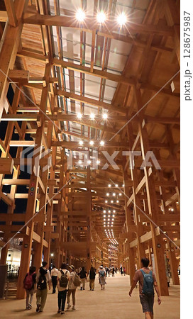 大阪 関西万博 ライトアップされた大屋根リングの下を歩く人々 大阪 関西万博 ライトアップされた大屋根リングの下を歩く人々 128675987