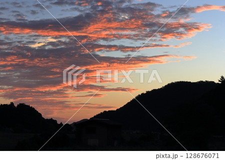 東の空がオレンジ色に染まる夏の早朝 128676071