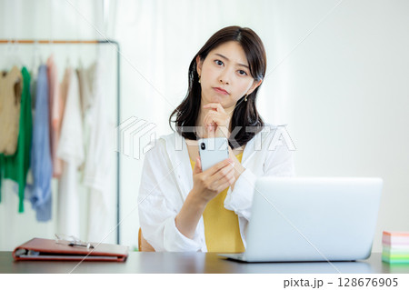 スマホを見て困る若い女性 スマホを見て困る若い女性 128676905