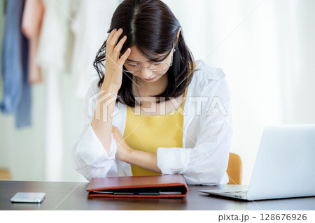 ノートパソコンを使いながら困っている若い女性 128676926