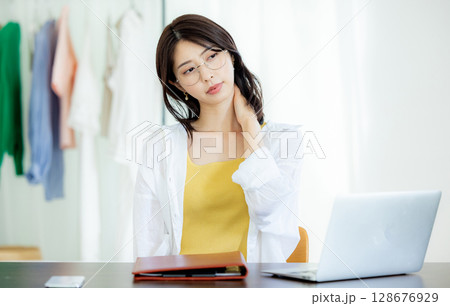 テレワークで働く若い女性　肩凝り 128676929