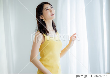 カーテンを開ける女性 カーテンを開ける女性 128676947