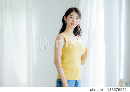 カーテンを開ける女性 128676952