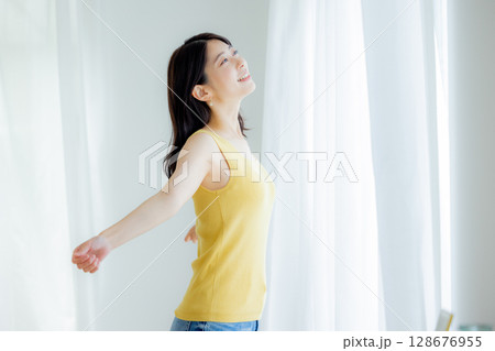 カーテンを開ける女性 128676955