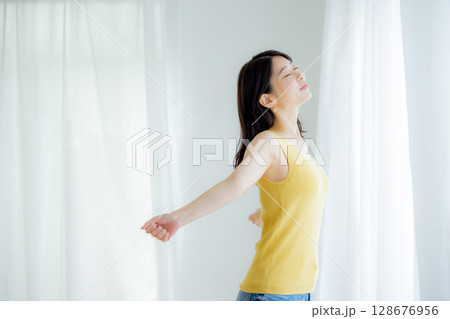 カーテンを開ける女性 128676956