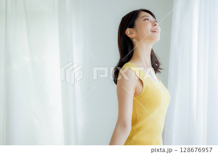 カーテンを開ける女性 128676957