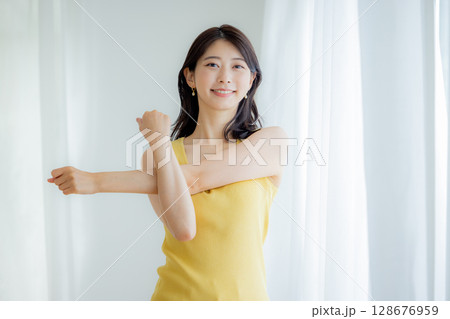 カーテンから日差しを浴びる女性 カーテンから日差しを浴びる女性 128676959