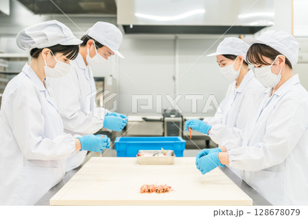 食材の下準備,仕込みをする衛生服姿の男女スタッフ 食材の下準備,仕込みをする衛生服姿の男女スタッフ 128678079