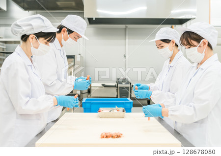 食材の下準備,仕込みをする衛生服姿の男女スタッフ 食材の下準備,仕込みをする衛生服姿の男女スタッフ 128678080