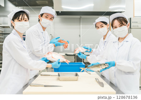 魚を調理するコックコート姿の男女スタッフ（調理師・料理人・生鮮市場・食品加工） 128678136