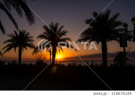沖縄の沈む夕陽とシルエット 128678184
