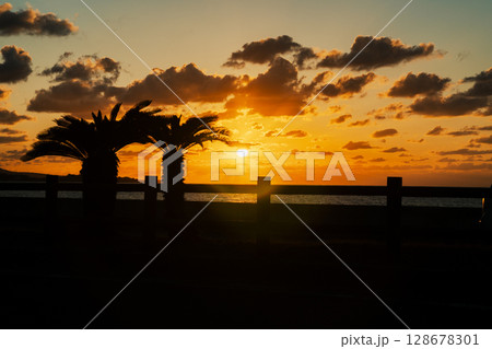 沖縄の沈む夕陽とシルエット 128678301